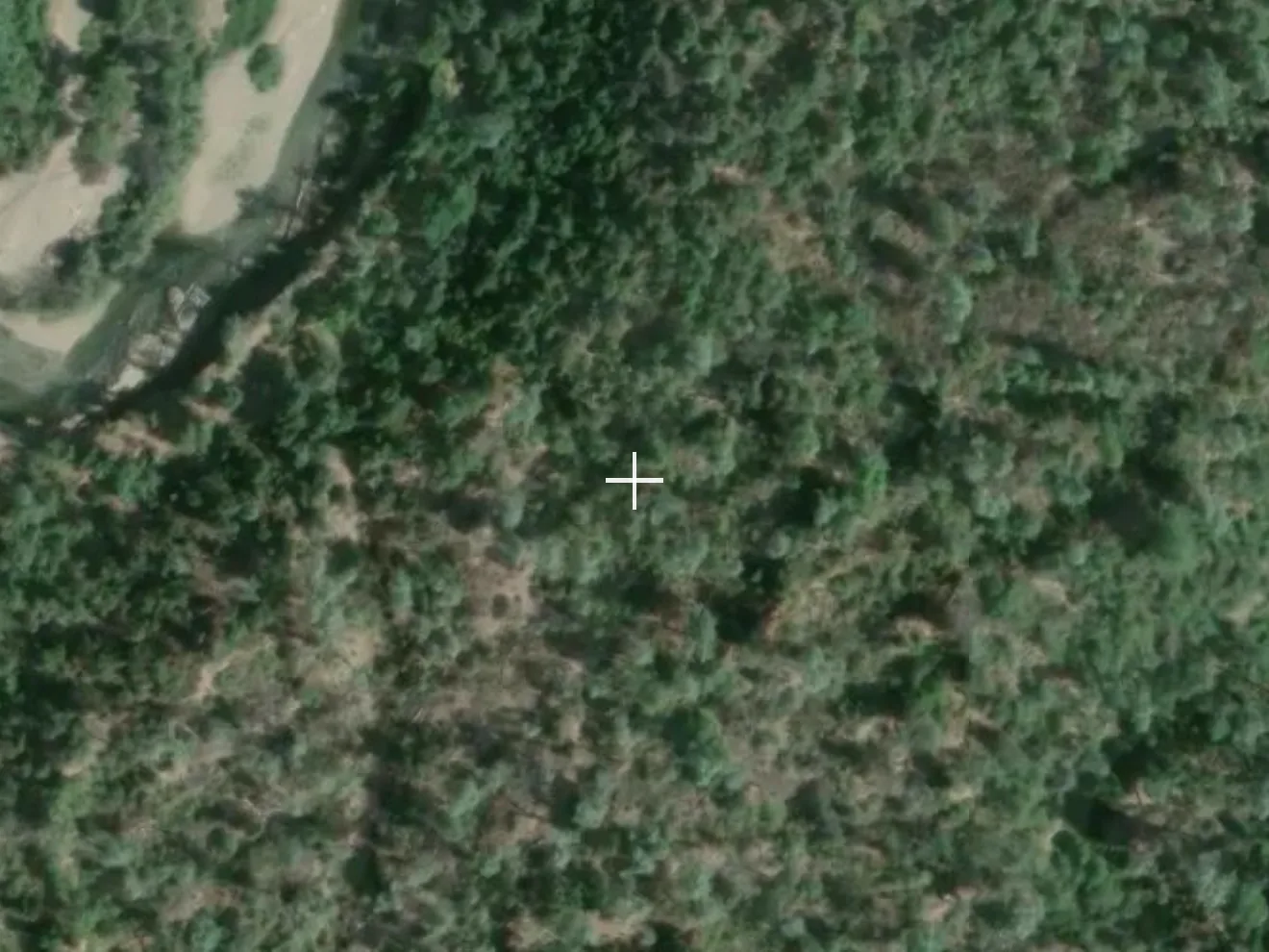 Satellite view of a bend on Clear Creek, showing unbroken green tree canopy and brush with no ground detail visible